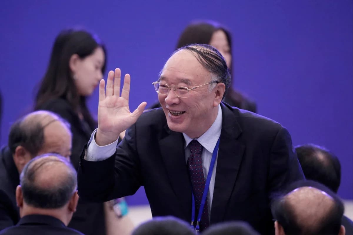 A senior Chinese official waves while greeting attendees at a public event