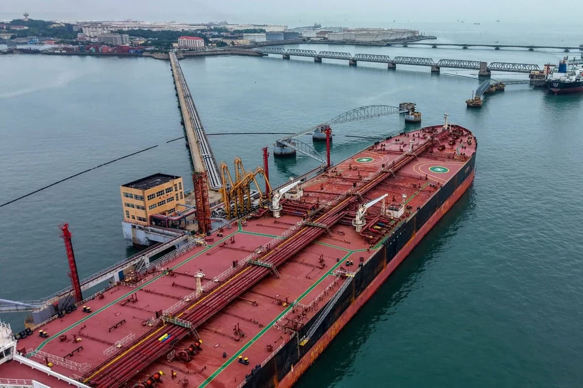 An oil tanker docked at a Chinese port terminal, connected to loading pipelines