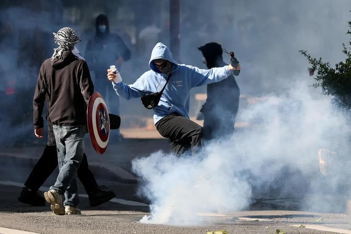 Protesters stand amid clouds of tear gas during a demonstration in France