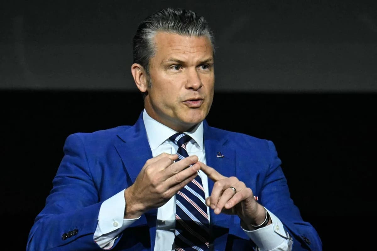 A man in a blue suit gestures while speaking at a public event