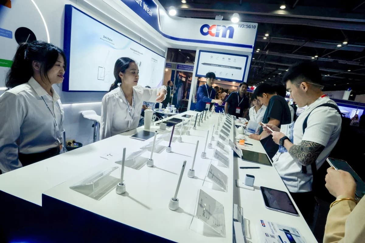 Visitors examine devices at a trading pavilion booth during a Hong Kong electronics show