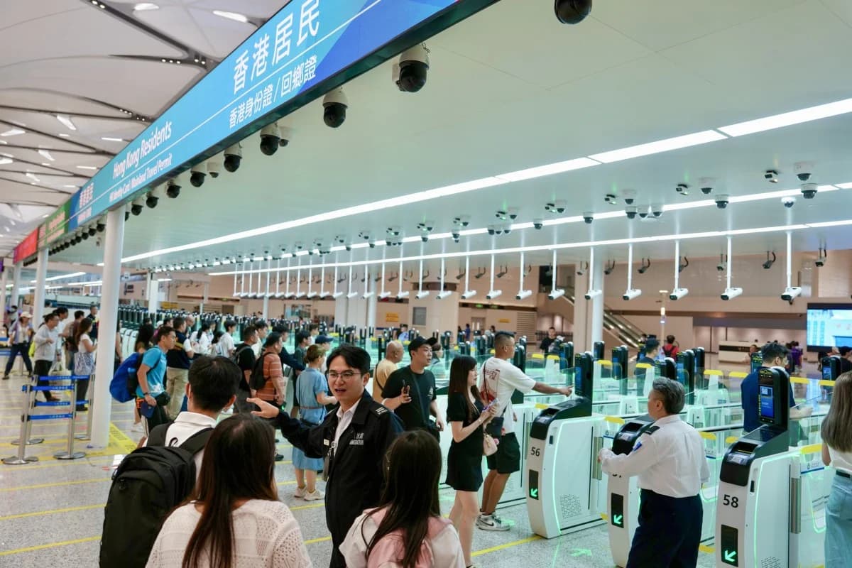 Travelers queue at e-channel gates during a crowded holiday period at the Huanggang crossing
