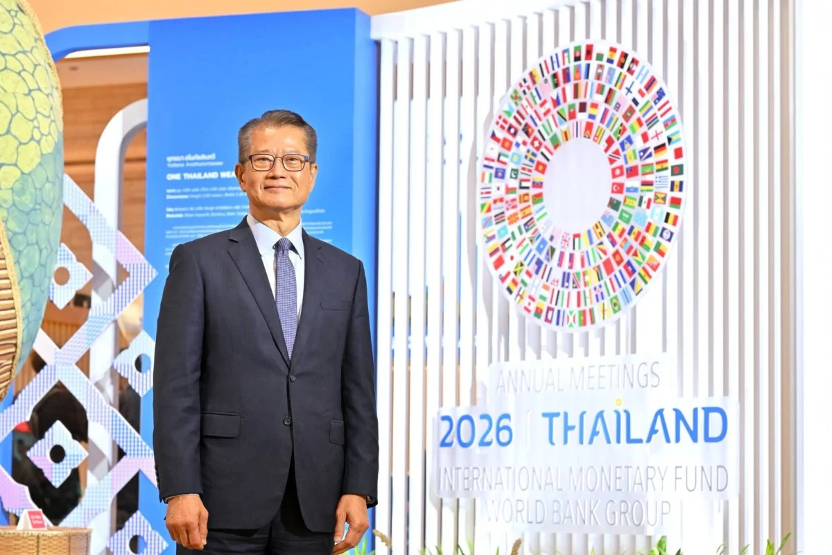 Hong Kong Financial Secretary Paul Chan stands in front of an IMF and World Bank annual meetings sign in Bangkok