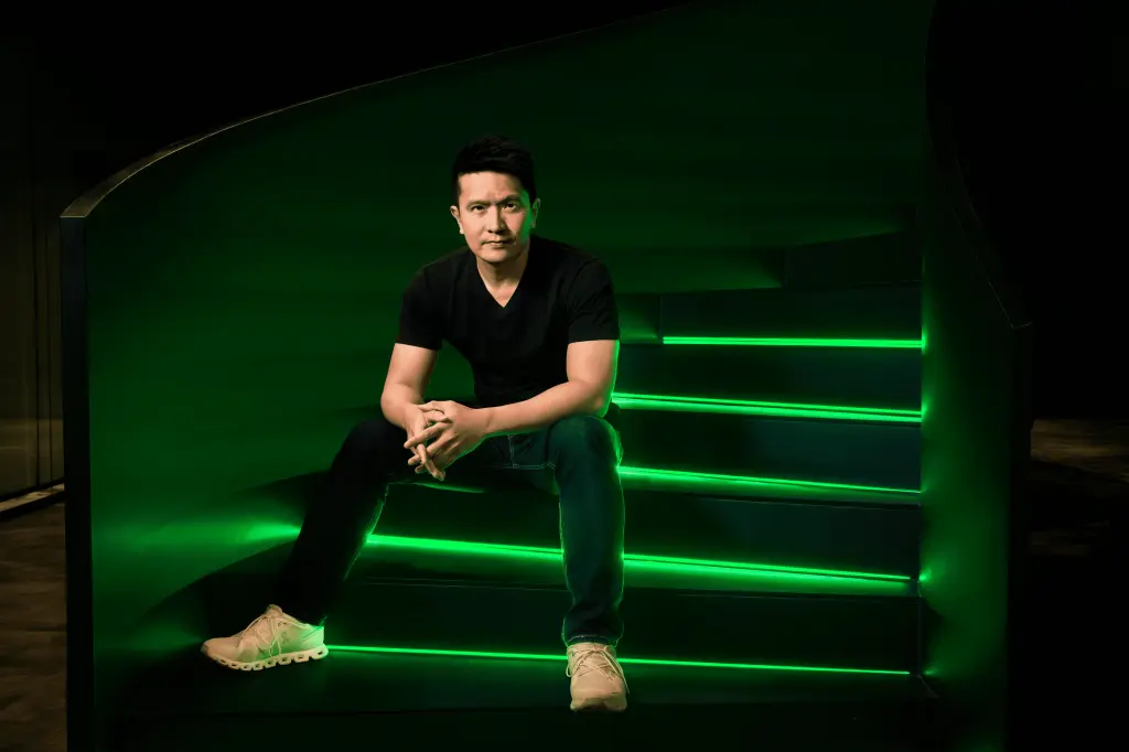 Razer co-founder and CEO Min-Liang Tan sits on illuminated green steps