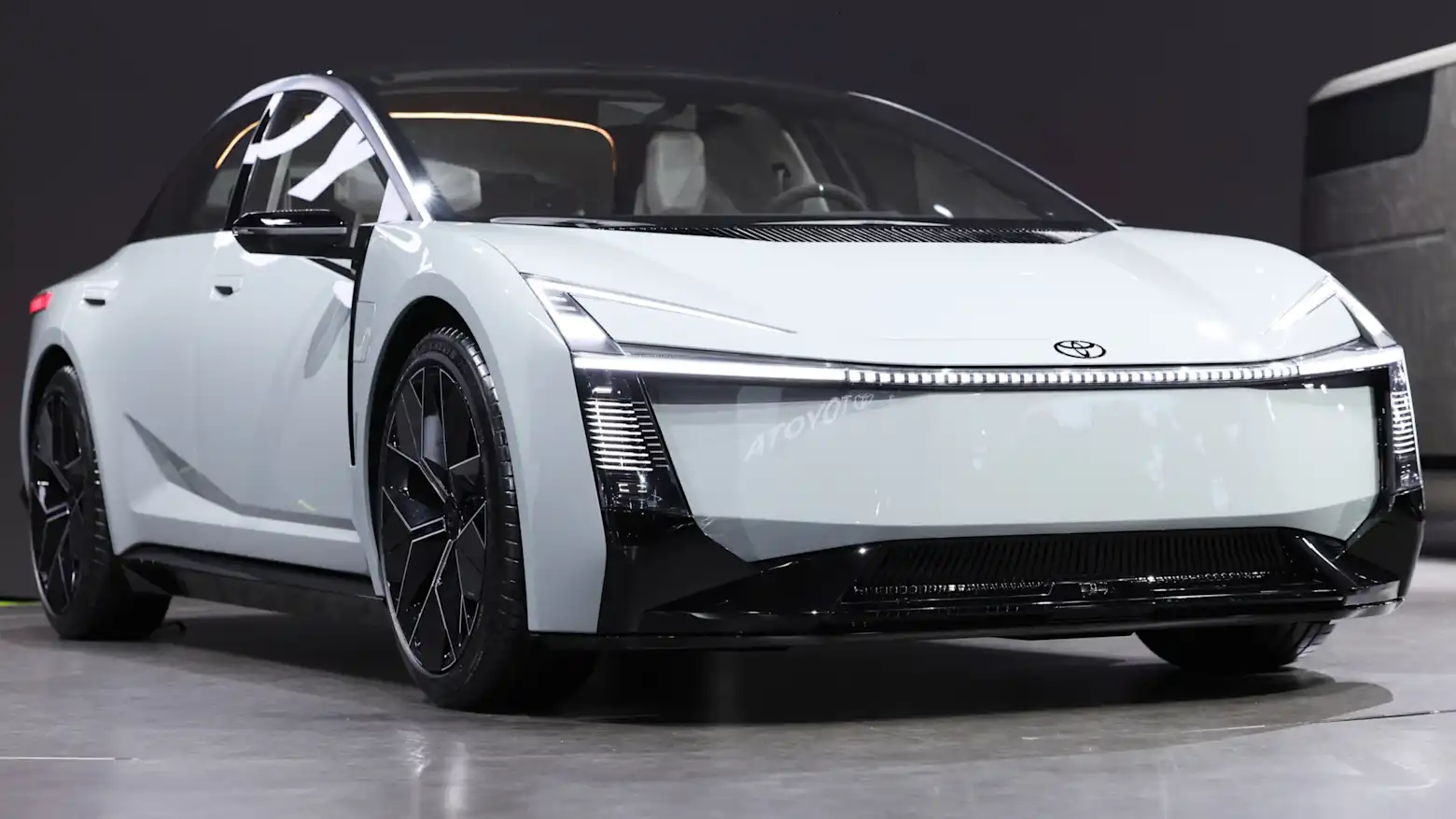 A white next-generation Toyota concept sedan on display at an auto show
