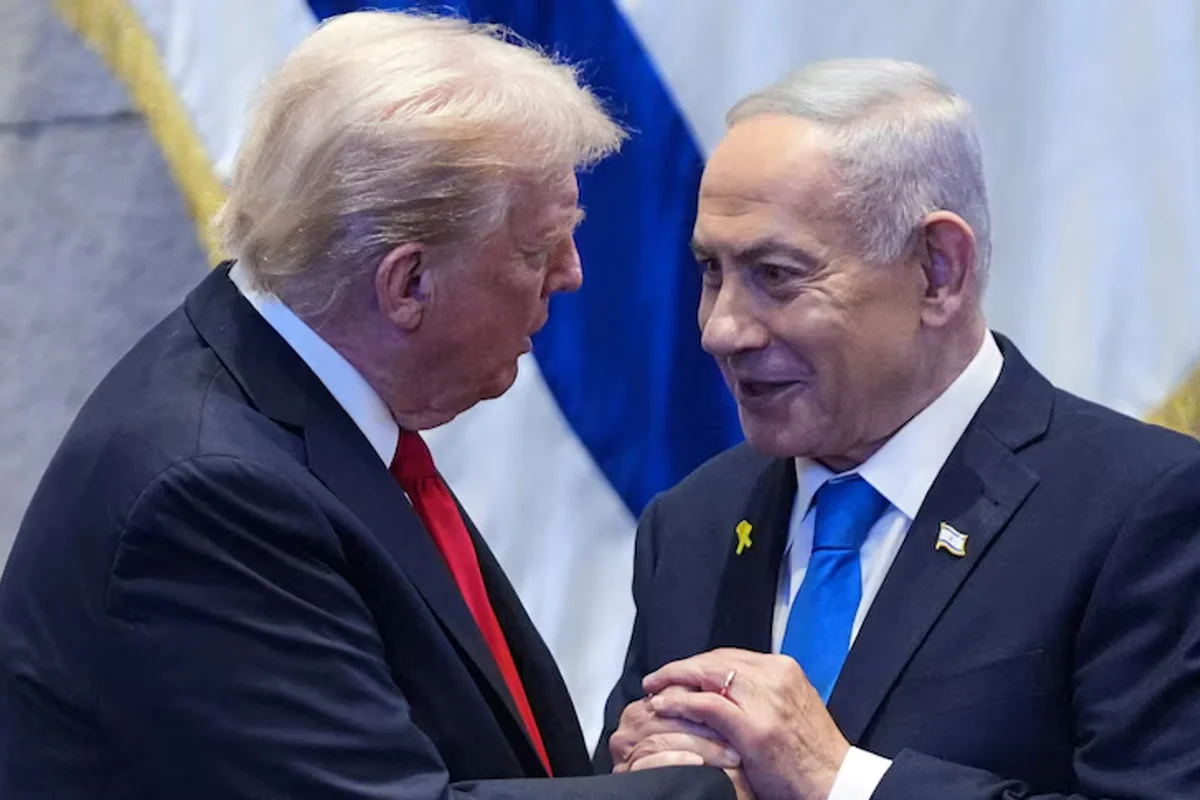 Donald Trump and Benjamin Netanyahu clasp hands in front of Israeli flags