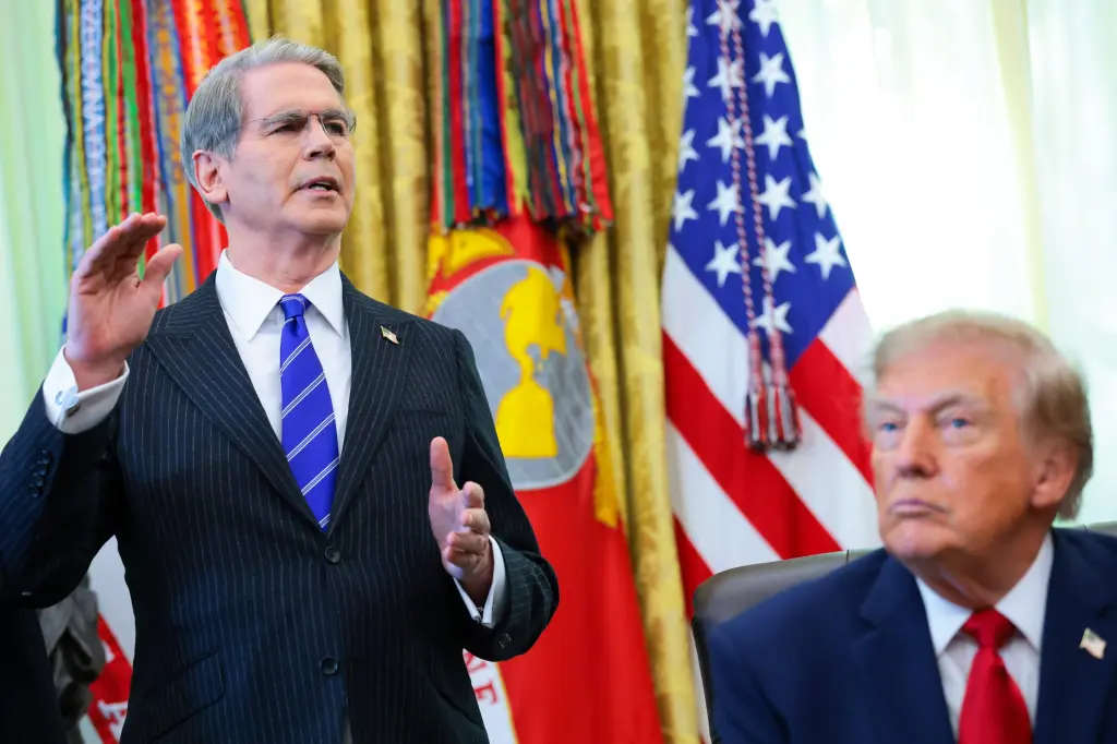 A US official gestures while speaking in the Oval Office as President Trump looks on