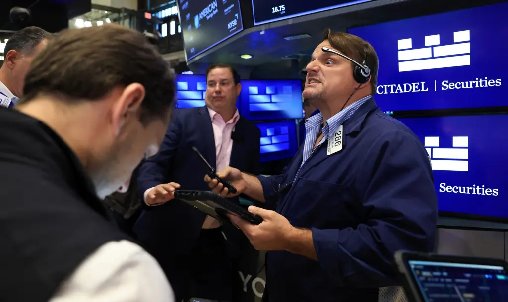 Traders work on the floor of the New York Stock Exchange near a Citadel Securities display