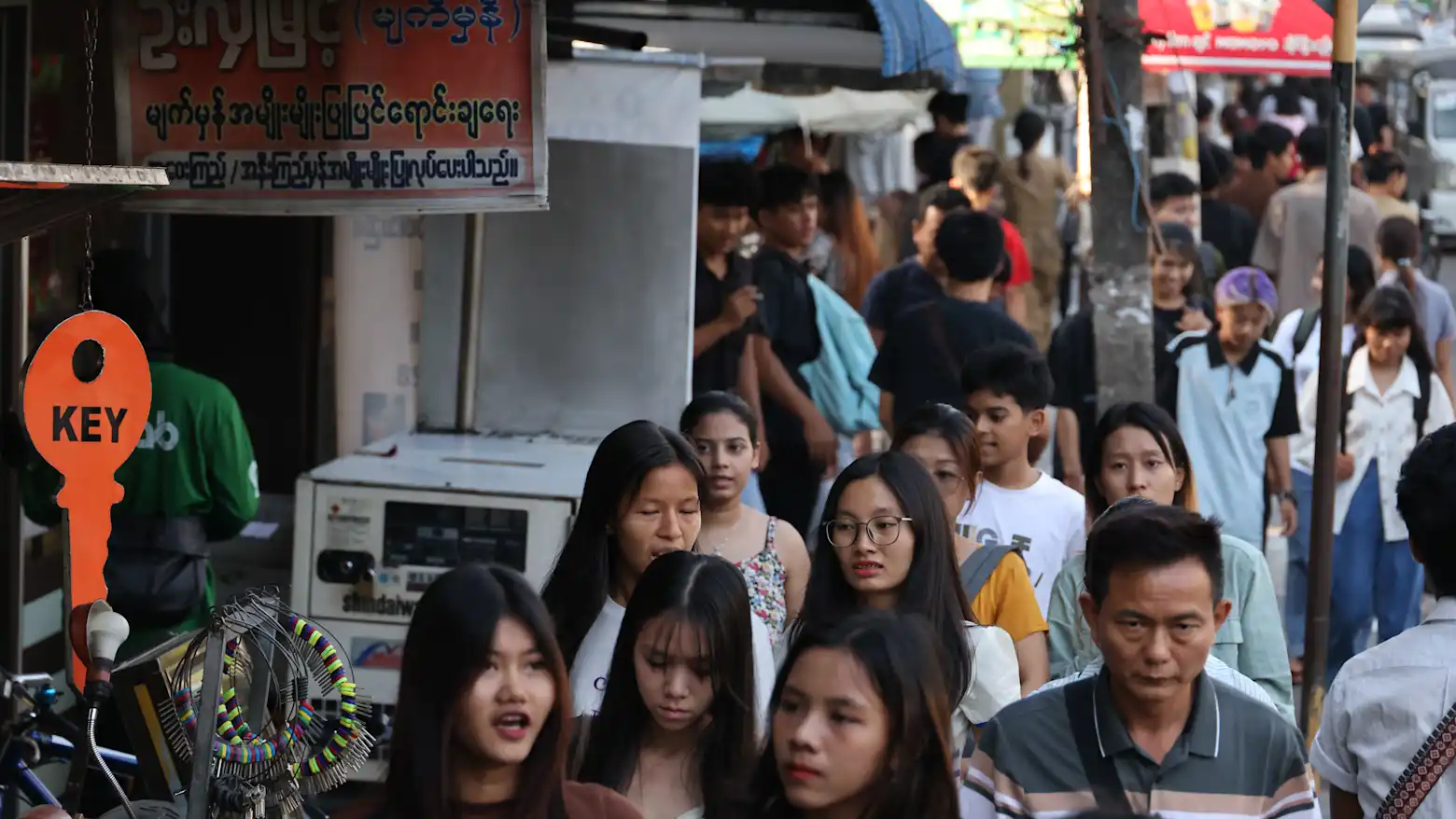 Crowds of pedestrians walk along a busy downtown street in Yangon, Myanmar